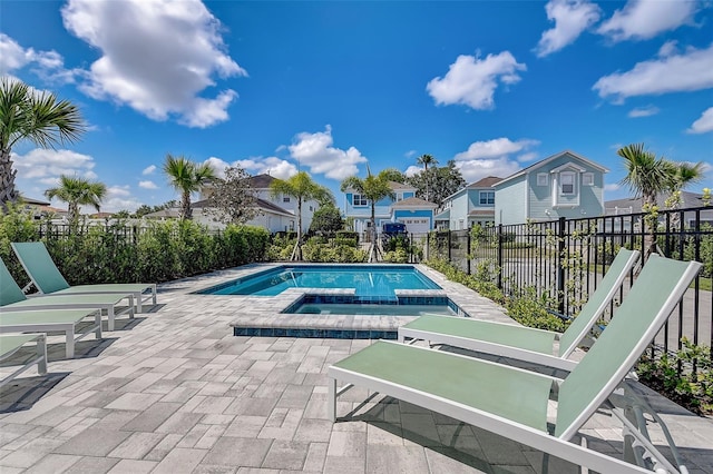 view of swimming pool featuring an in ground hot tub and a patio