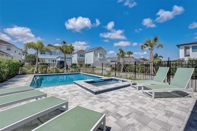 view of pool with a patio area and an in ground hot tub