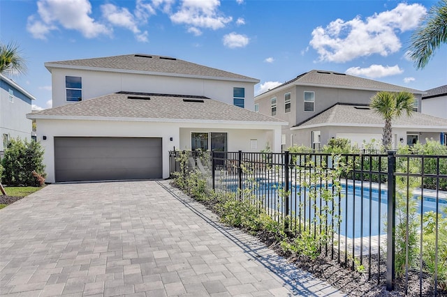 view of front of house with a garage and a fenced in pool