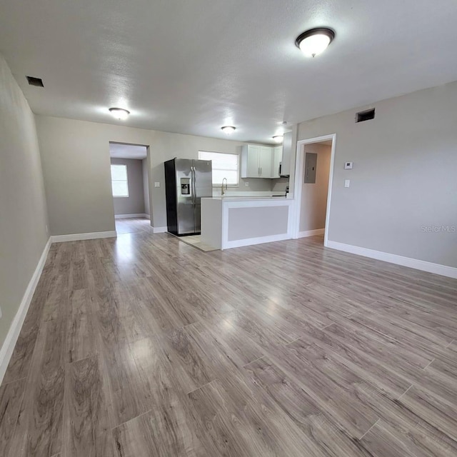 unfurnished living room featuring sink and light wood-type flooring