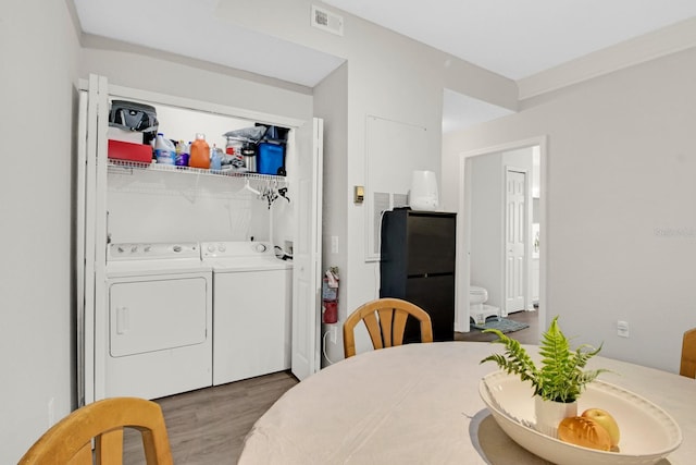 clothes washing area with hardwood / wood-style flooring, hookup for a washing machine, and washing machine and clothes dryer