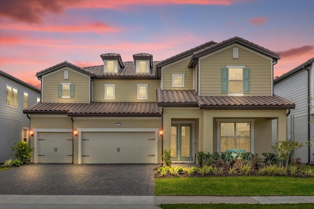 mediterranean / spanish-style house featuring a garage and a yard