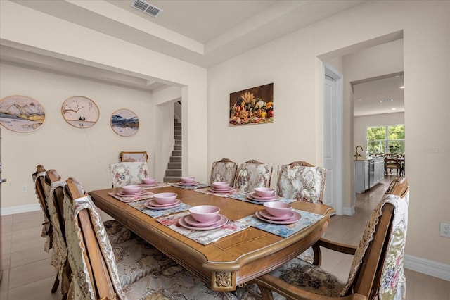 tiled dining room featuring sink