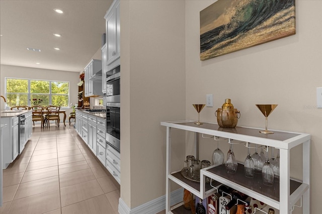 kitchen with sink, light tile patterned floors, white cabinets, and appliances with stainless steel finishes