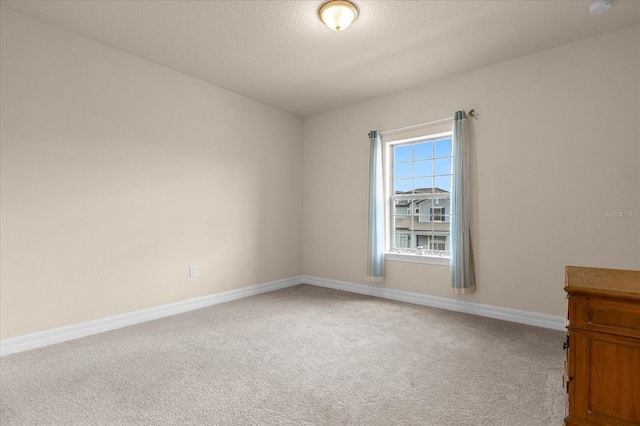 carpeted spare room with a textured ceiling