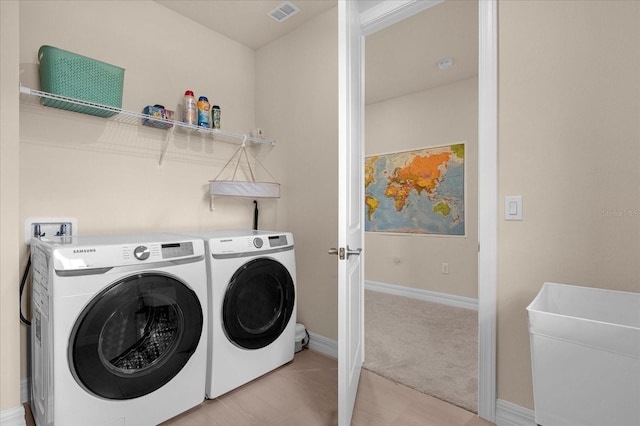 laundry room with washing machine and dryer and light colored carpet