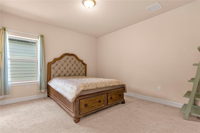 bedroom with light carpet and a textured ceiling