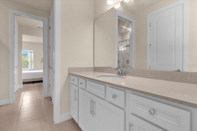 bathroom with tile patterned flooring, vanity, and a shower