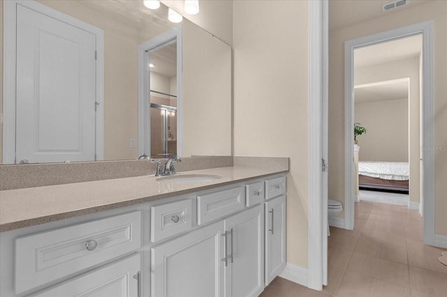 bathroom featuring tile patterned flooring, vanity, and toilet