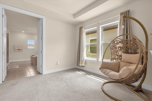 sitting room with a tray ceiling and light colored carpet