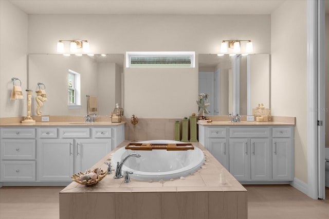 bathroom featuring vanity and tiled tub