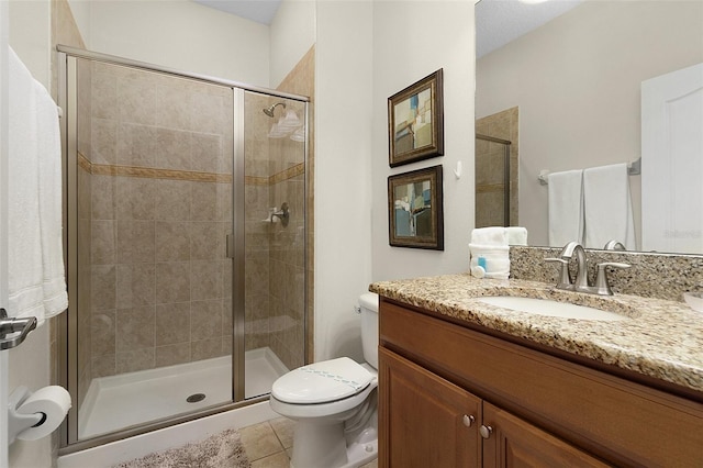 bathroom featuring tile floors, a shower with shower door, toilet, and large vanity