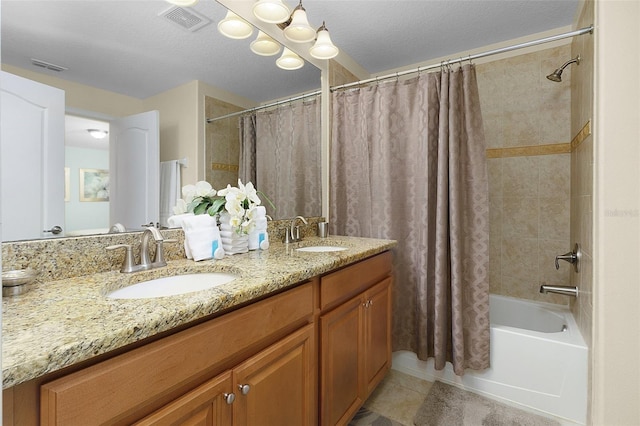 bathroom featuring tile flooring, dual vanity, shower / bath combo, and a textured ceiling