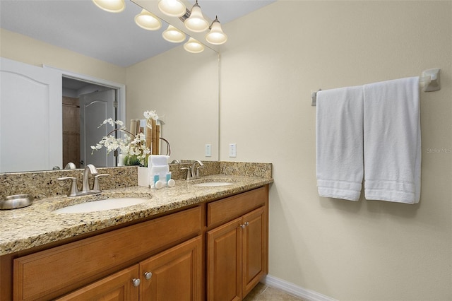 bathroom featuring a notable chandelier, vanity with extensive cabinet space, and dual sinks