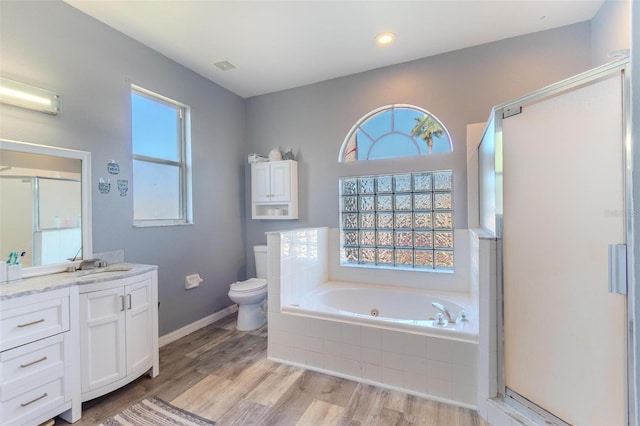 full bathroom with hardwood / wood-style flooring, vanity, independent shower and bath, and toilet