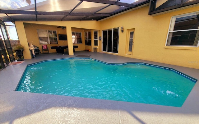 view of swimming pool featuring glass enclosure and a patio