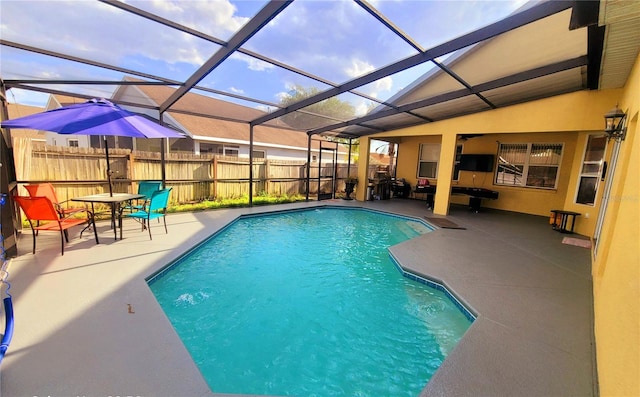 view of swimming pool featuring glass enclosure and a patio area