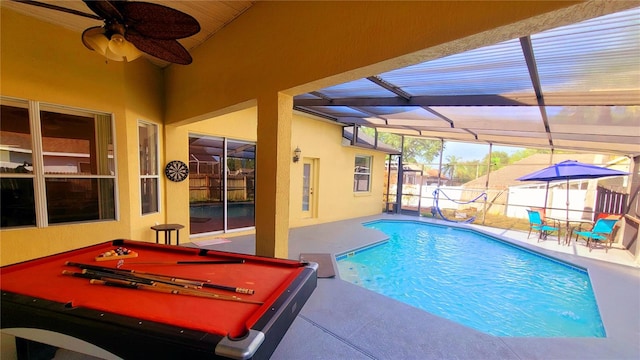 view of pool with glass enclosure, ceiling fan, and a patio area