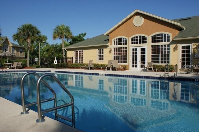 view of swimming pool with french doors and a patio