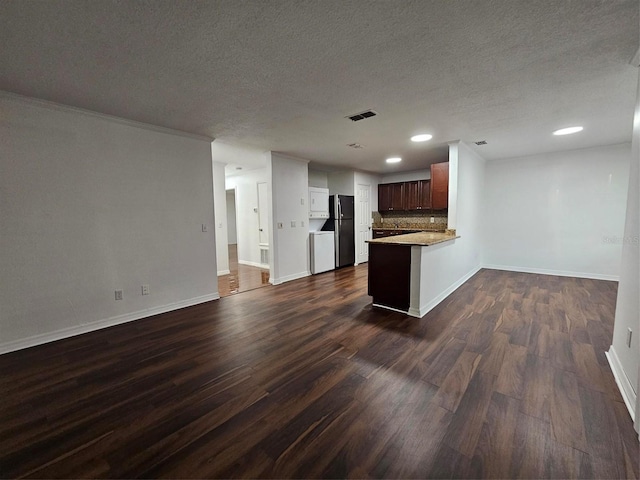 kitchen featuring a textured ceiling, stainless steel refrigerator, kitchen peninsula, and dark hardwood / wood-style floors