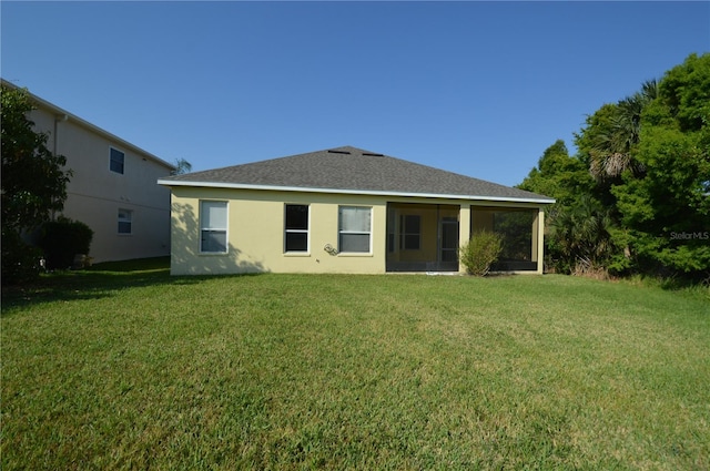 back of house with a lawn and a sunroom