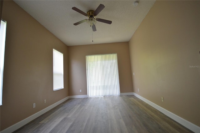 empty room with ceiling fan, a textured ceiling, and a healthy amount of sunlight