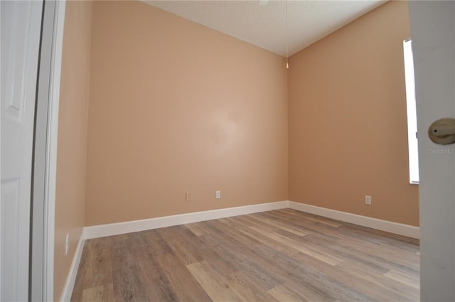 spare room with a textured ceiling and light hardwood / wood-style floors