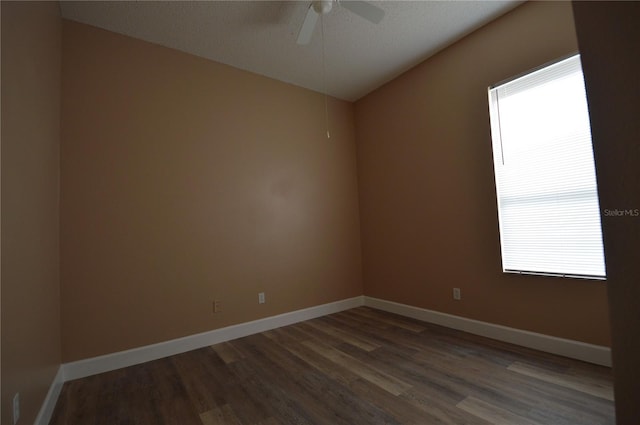 empty room featuring ceiling fan, a textured ceiling, and dark hardwood / wood-style floors