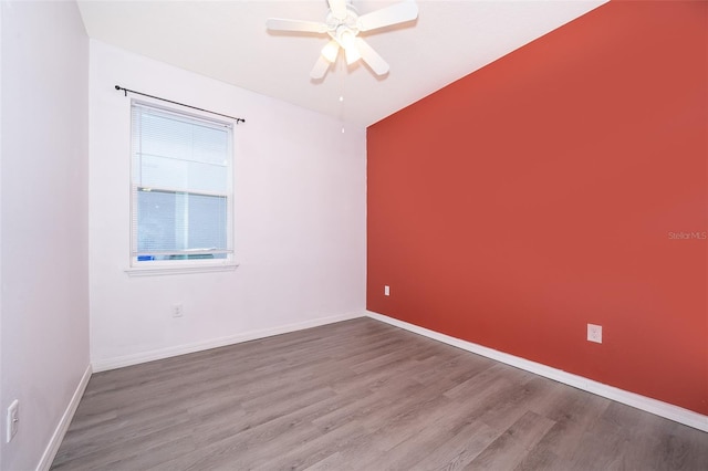 unfurnished room with ceiling fan and dark wood-type flooring