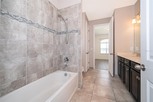 bathroom featuring tiled shower / bath, tile flooring, and vanity