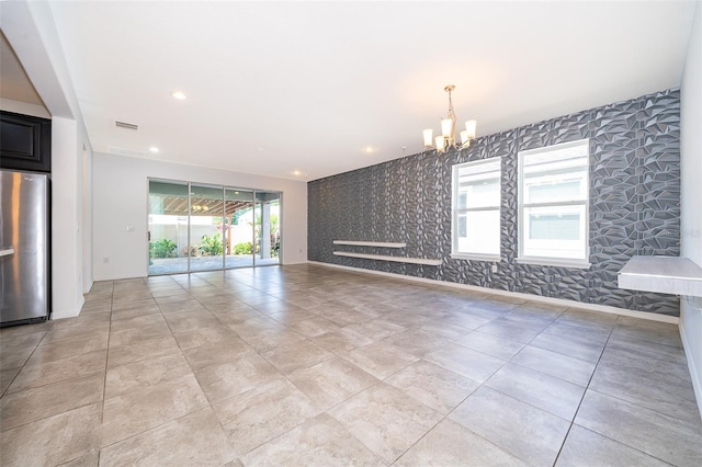 unfurnished living room featuring a notable chandelier and light tile floors