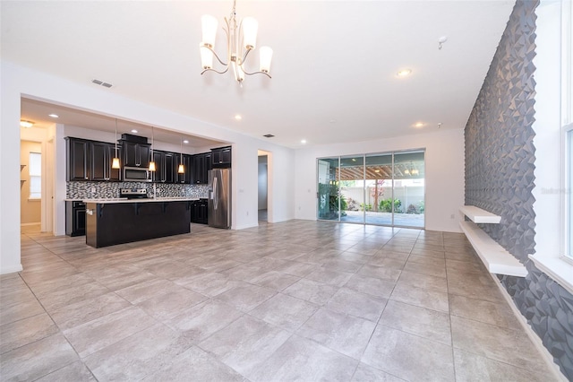 kitchen featuring appliances with stainless steel finishes, a center island, light tile floors, tasteful backsplash, and pendant lighting