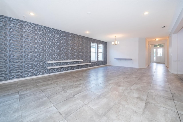 tiled empty room with a chandelier