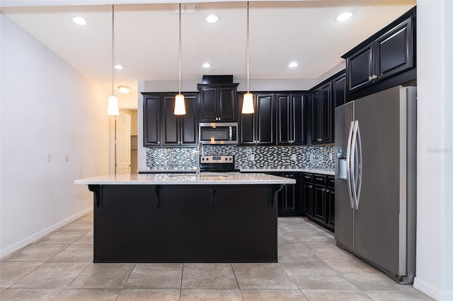 kitchen with hanging light fixtures, stainless steel appliances, light tile floors, and an island with sink