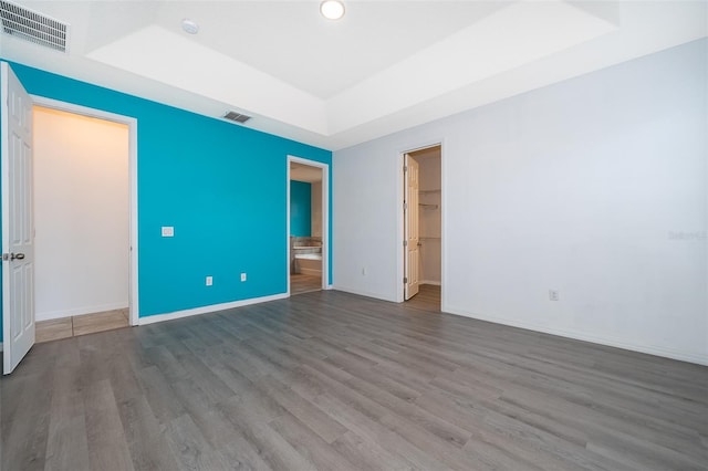 unfurnished room featuring hardwood / wood-style floors and a tray ceiling