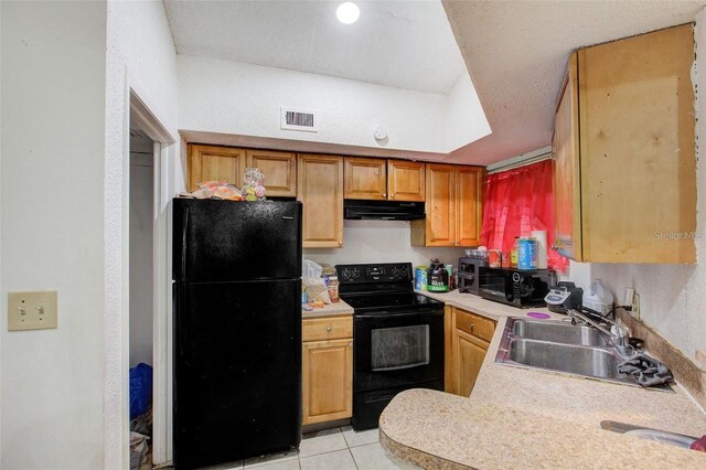 kitchen featuring sink, black appliances, and light tile floors