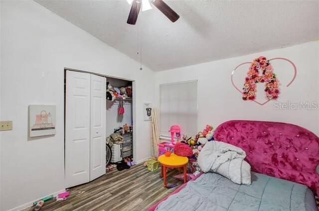 bedroom featuring a closet, wood-type flooring, ceiling fan, and lofted ceiling