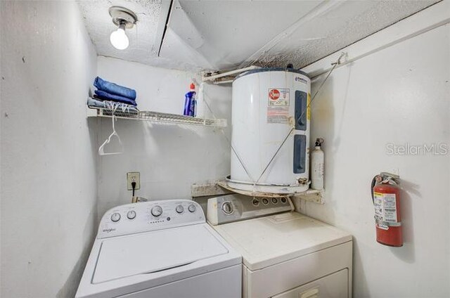 clothes washing area with water heater and separate washer and dryer