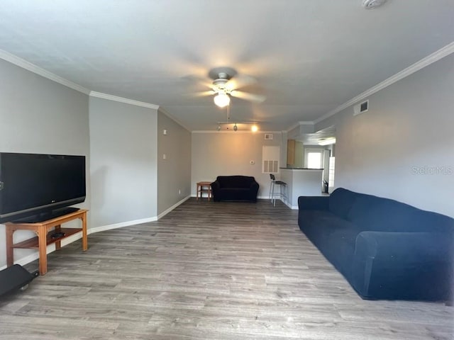 living room with wood-type flooring, ceiling fan, and ornamental molding