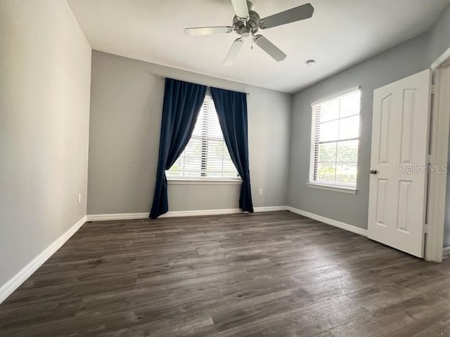 empty room featuring dark hardwood / wood-style flooring and ceiling fan