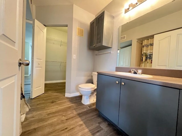 bathroom with vanity, hardwood / wood-style flooring, and toilet