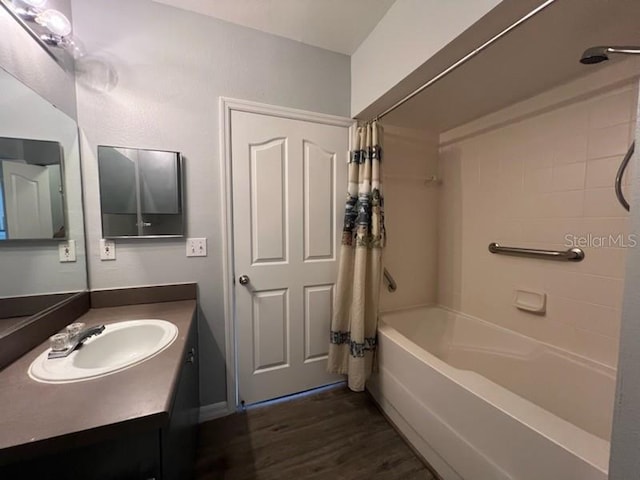 bathroom featuring shower / tub combo, vanity with extensive cabinet space, and hardwood / wood-style flooring