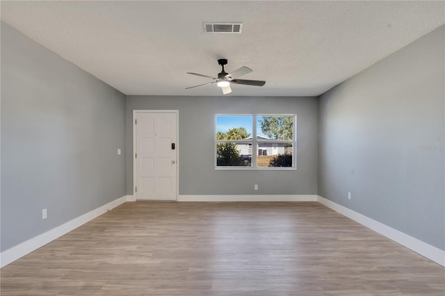 empty room featuring a textured ceiling, hardwood / wood-style floors, and ceiling fan