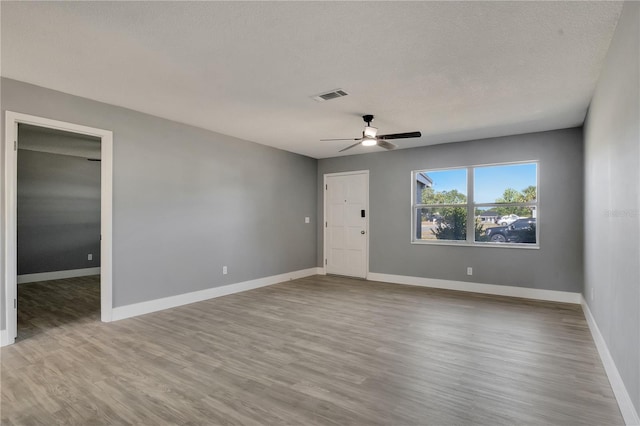 unfurnished room with ceiling fan, hardwood / wood-style flooring, and a textured ceiling