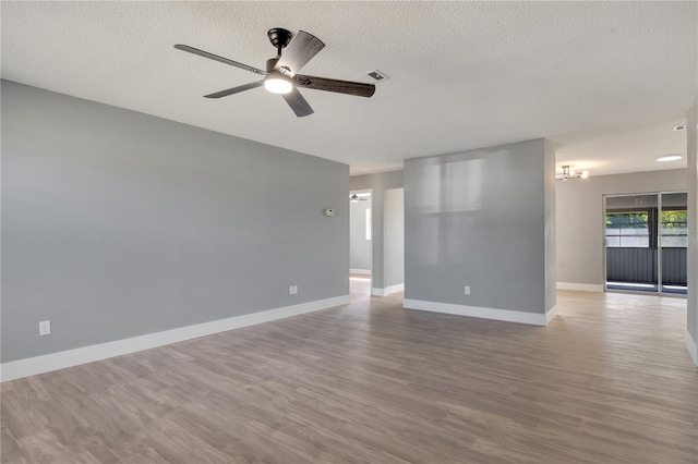 empty room with ceiling fan, hardwood / wood-style flooring, and a textured ceiling