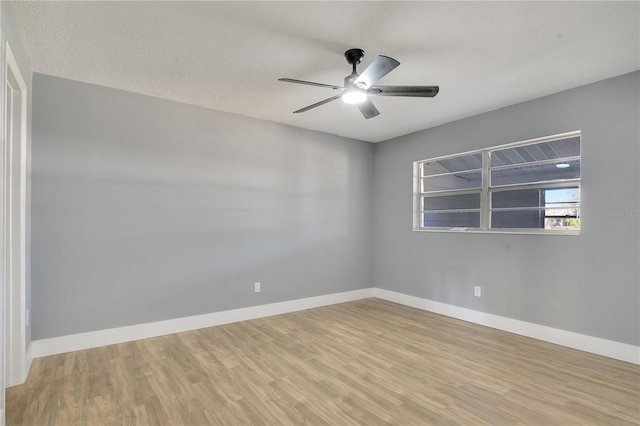 spare room featuring light hardwood / wood-style floors, ceiling fan, and a textured ceiling