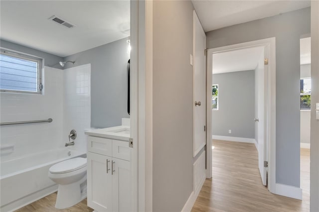 full bathroom with tiled shower / bath combo, wood-type flooring, vanity, and toilet