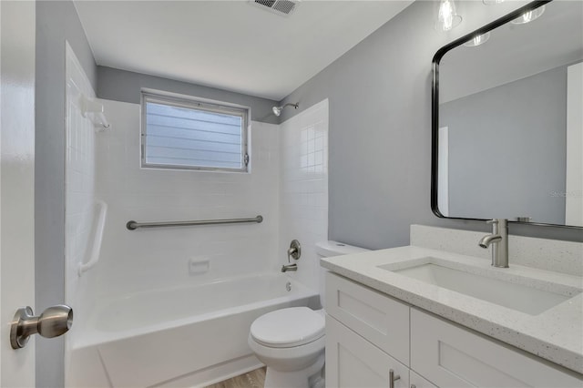 full bathroom with tiled shower / bath combo, hardwood / wood-style floors, vanity with extensive cabinet space, and toilet