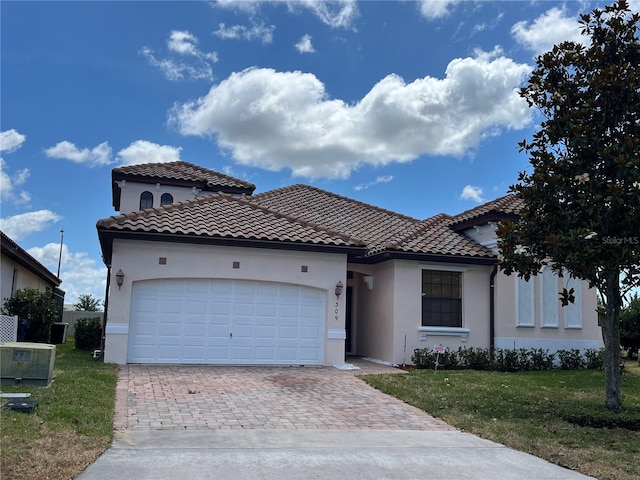 mediterranean / spanish home with central AC, a garage, and a front yard