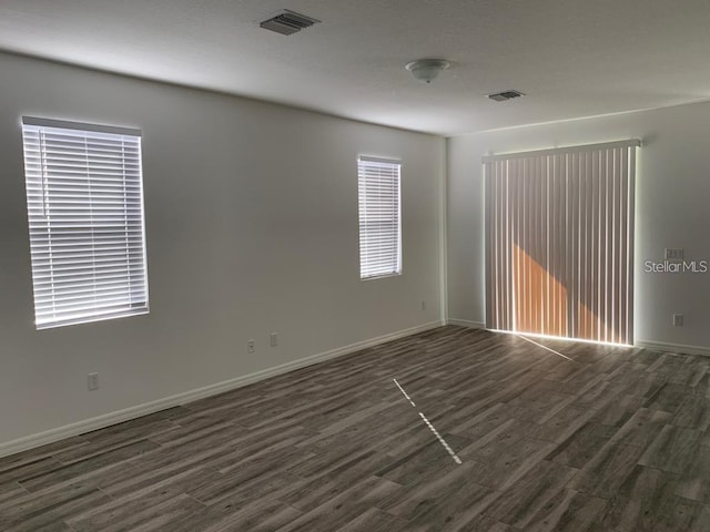 unfurnished room with dark hardwood / wood-style flooring